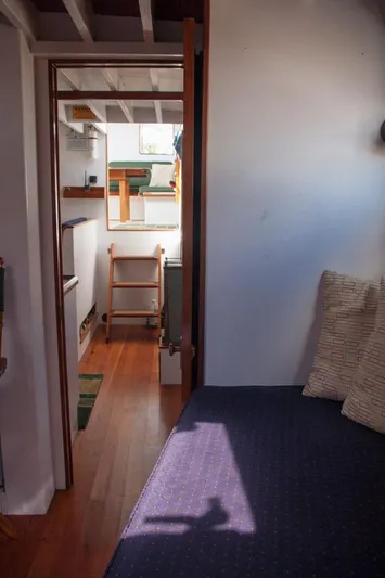 Miss Nina Yacht Photos Pics Interior of 1996 Custom Bolger PH Shoal-draft Ketch, featuring cozy seating and wooden flooring.