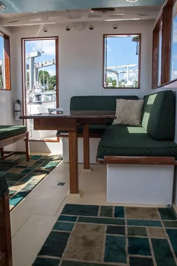 Miss Nina Yacht Photos Pics Interior of 1996 Custom Bolger PH Shoal-draft Ketch with green seating and geometric rugs.