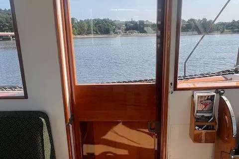 Miss Nina Yacht Photos Pics Interior view of 1996 Custom Bolger PH Shoal-draft Ketch with wooden door and water scenery.