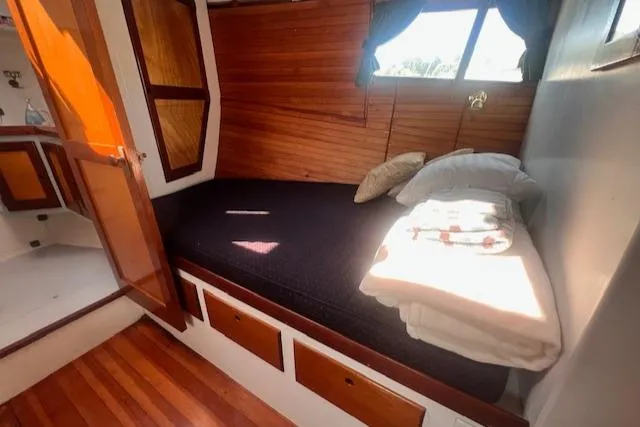 Miss Nina Yacht Photos Pics Cozy cabin interior of 1996 Custom Bolger PH Shoal-draft Ketch with wooden accents and bedding.