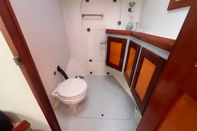 Miss Nina Yacht Photos Pics 1996 Custom Bolger PH Shoal-draft Ketch bathroom with wooden cabinets and marine toilet.