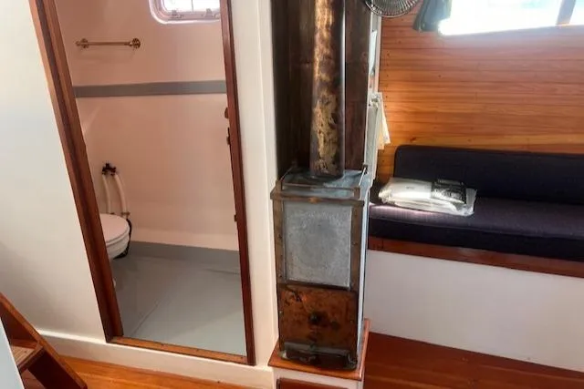 Miss Nina Yacht Photos Pics Interior of 1996 Custom Bolger PH Shoal-draft Ketch with wood stove and seating area.