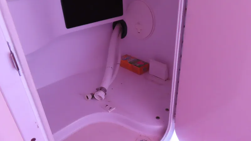  Yacht Photos Pics Storage compartment inside a 2009 Donzi 35ZR boat, featuring a hose and small items.