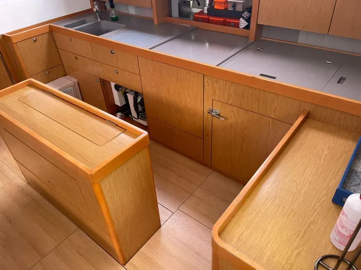 La Vieja Yacht Photos Pics Modern kitchen interior of 2011 Beneteau Sense 50 yacht with wooden cabinetry and stainless steel countertops.