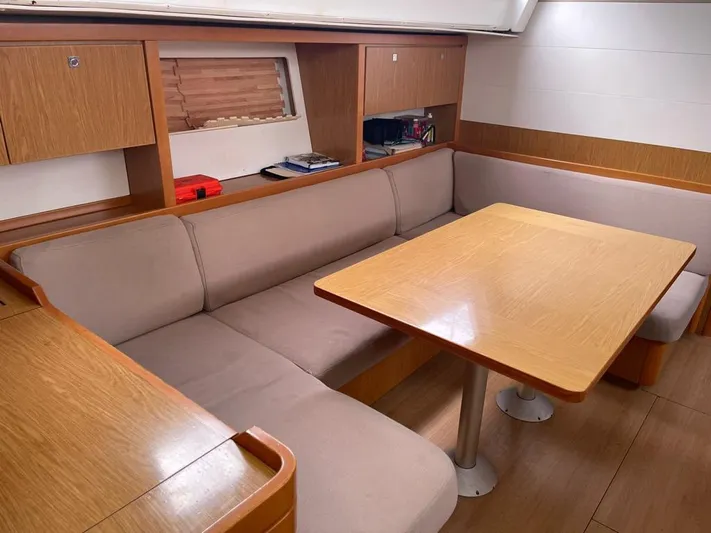 La Vieja Yacht Photos Pics Interior of 2011 Beneteau Sense 50 yacht with wooden table and beige seating.