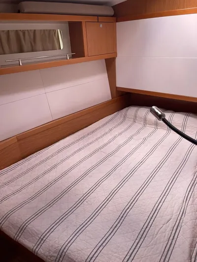 La Vieja Yacht Photos Pics Cozy bedroom in 2011 Beneteau Sense 50 yacht with striped bedding and wooden cabinetry.