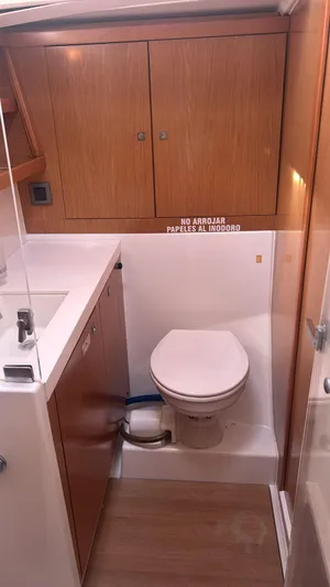 La Vieja Yacht Photos Pics Beneteau Sense 50 yacht bathroom, 2011 model, featuring wooden cabinets and modern fixtures.