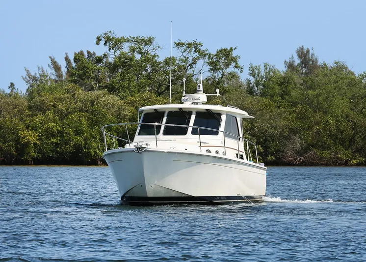 Traveller Yacht Photos Pics 2016 Back Cove 34 boat cruising on a calm waterway with lush greenery.
