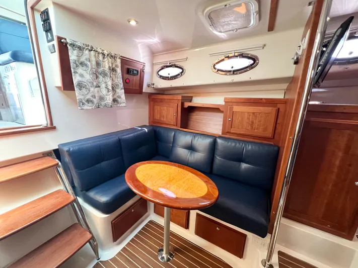 Traveller Yacht Photos Pics 2016 Back Cove 34 interior with blue seating, wooden table, and nautical decor.