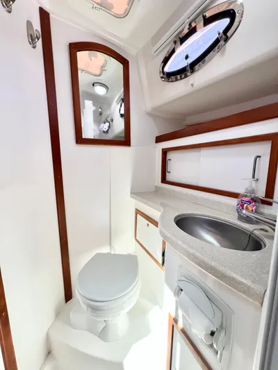 Traveller Yacht Photos Pics 2016 Back Cove 34 yacht bathroom with sink, toilet, mirror, and porthole window.