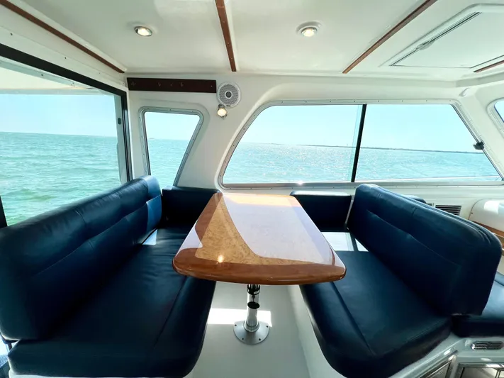 Traveller Yacht Photos Pics Interior of 2016 Back Cove 34 yacht with ocean view, featuring elegant seating and wooden table.