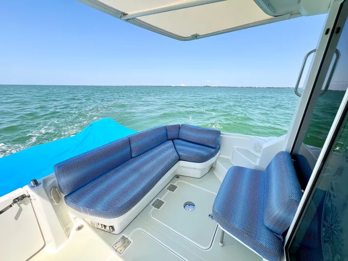 Traveller Yacht Photos Pics Back Cove 34 boat interior with blue seating, overlooking calm ocean waters.