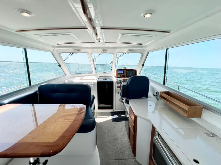 Traveller Yacht Photos Pics Interior of 2016 Back Cove 34 boat with seating, table, and ocean view.