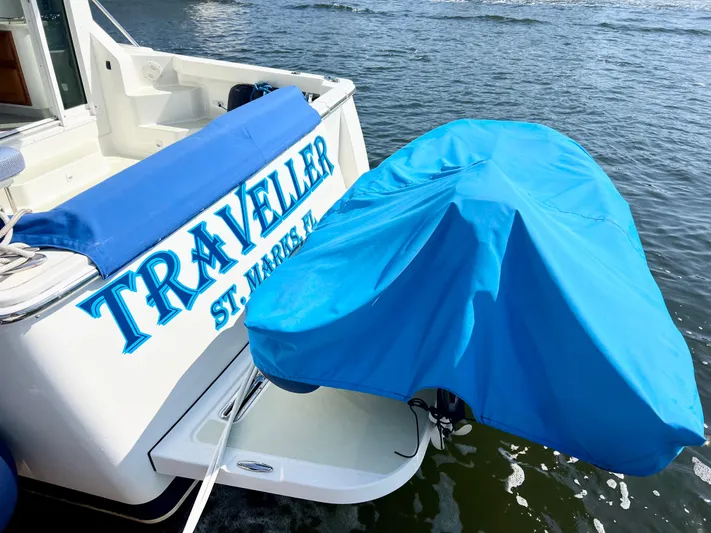Traveller Yacht Photos Pics 2016 Back Cove 34 boat named "Traveller" with blue cover on water.
