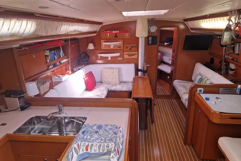  Yacht Photos Pics Luxurious interior of a 2003 Grand Soleil 45 yacht, featuring cozy seating and elegant wood finishes.