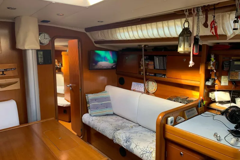  Yacht Photos Pics Cozy interior of 2003 Grand Soleil 45 sailboat with wooden furnishings and nautical decor.