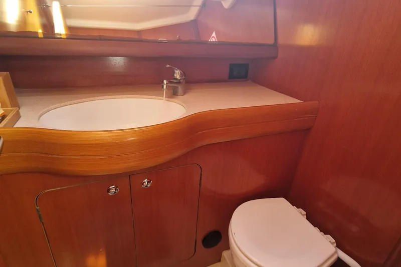  Yacht Photos Pics Grand Soleil 45 (2003) yacht bathroom with wooden cabinetry, sink, and toilet.