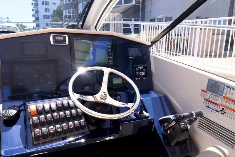 Ocean's Grace Yacht Photos Pics 2016 Pursuit SC 365i helm with steering wheel, control panel, and navigation screens.