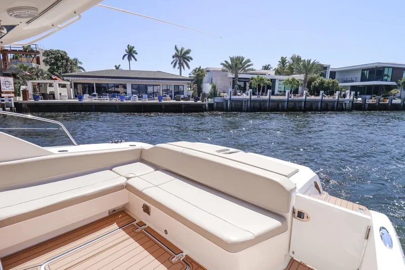 Ocean's Grace Yacht Photos Pics Luxury 2016 Pursuit SC 365i yacht with spacious seating, docked near waterfront homes.