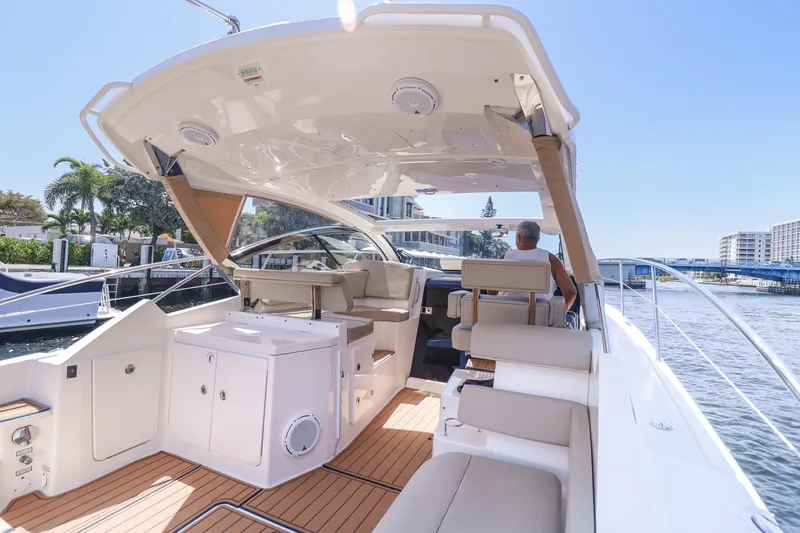 Ocean's Grace Yacht Photos Pics 2016 Pursuit SC 365i yacht interior with seating, docked by waterfront buildings.