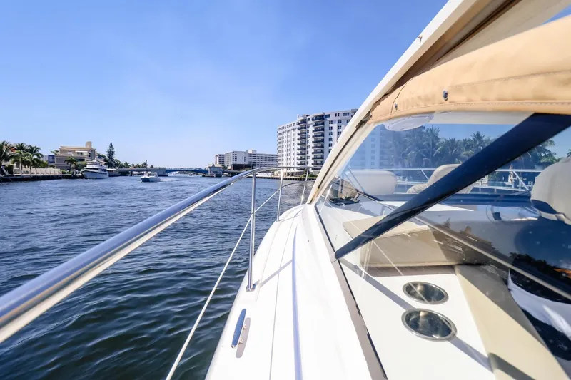 Ocean's Grace Yacht Photos Pics 2016 Pursuit SC 365i yacht cruising on a sunny waterway with cityscape views.