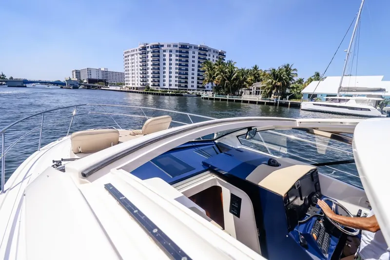 Ocean's Grace Yacht Photos Pics 2016 Pursuit SC 365i yacht cruising near waterfront buildings and palm trees.
