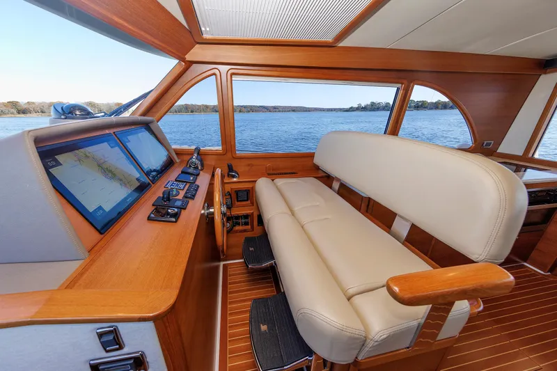 Friendly Persuasion Yacht Photos Pics 2019 Grand Banks 44 Eastbay SX helm with leather seating and navigation screens, overlooking serene waters.