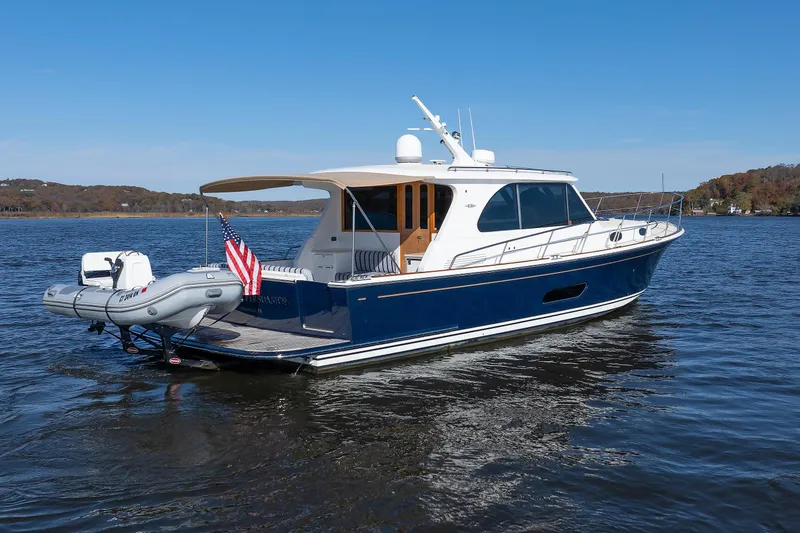 Friendly Persuasion Yacht Photos Pics 2019 Grand Banks 44 Eastbay SX yacht on calm water, featuring sleek design and American flag.