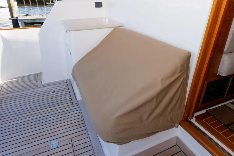 Friendly Persuasion Yacht Photos Pics 2019 Grand Banks 44 Eastbay SX deck with covered equipment and wooden flooring.