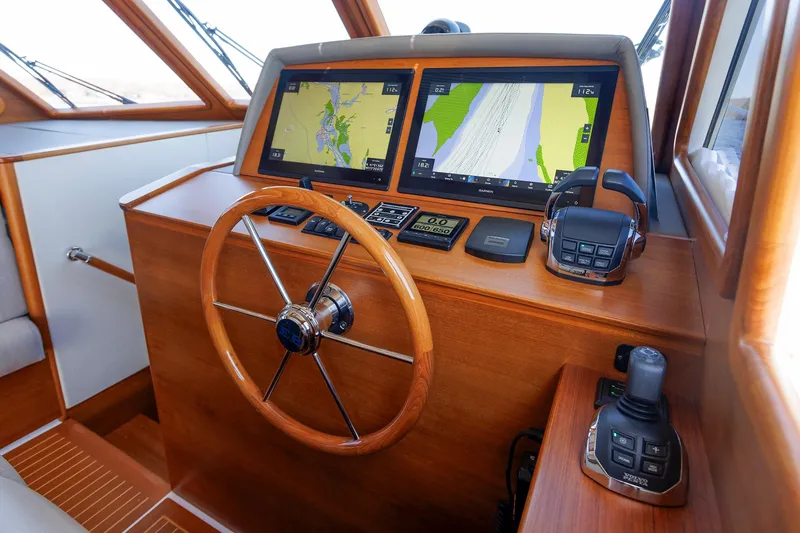 Friendly Persuasion Yacht Photos Pics 2019 Grand Banks 44 Eastbay SX helm with navigation screens and wooden steering wheel.