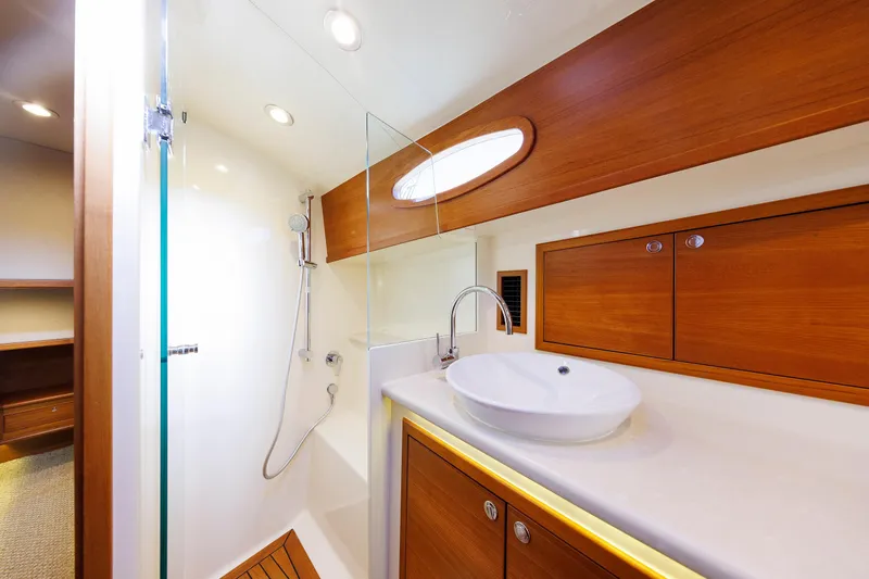Friendly Persuasion Yacht Photos Pics Luxurious bathroom in 2019 Grand Banks 44 Eastbay SX yacht with modern fixtures and wood accents.