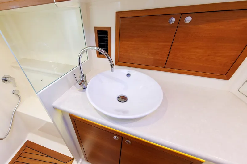 Friendly Persuasion Yacht Photos Pics Luxury bathroom sink on 2019 Grand Banks 44 Eastbay SX yacht, featuring elegant wood cabinetry.