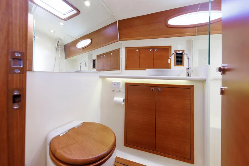 Friendly Persuasion Yacht Photos Pics Luxurious bathroom interior of 2019 Grand Banks 44 Eastbay SX yacht, featuring wood accents and modern fixtures.