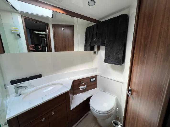  Yacht Photos Pics Luxurious bathroom in 2023 Maritimo M600 yacht with modern fixtures and wood accents.