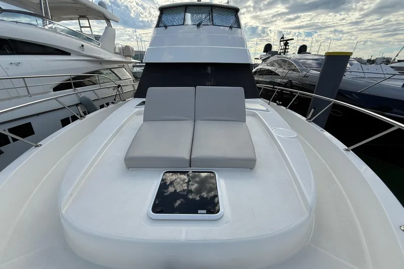  Yacht Photos Pics 2023 Maritimo M600 yacht with sleek deck and cushioned seating under cloudy sky.