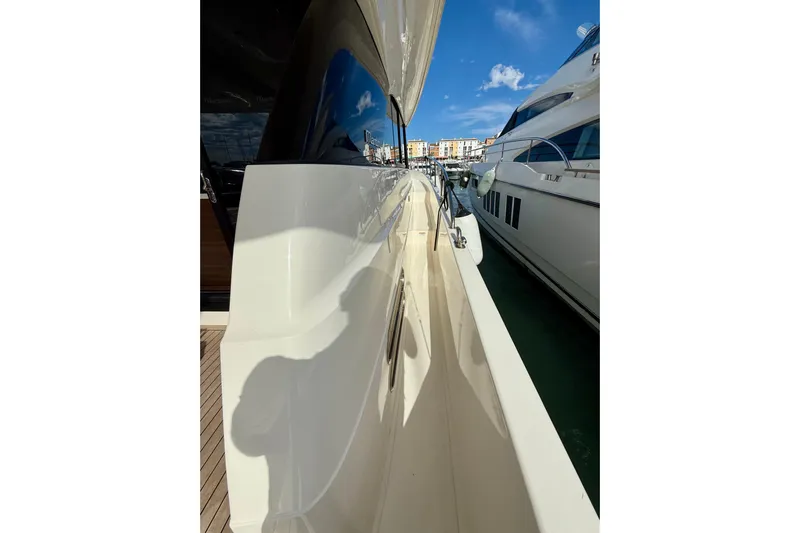  Yacht Photos Pics 2023 Maritimo M600 yacht side view, docked under clear blue sky.