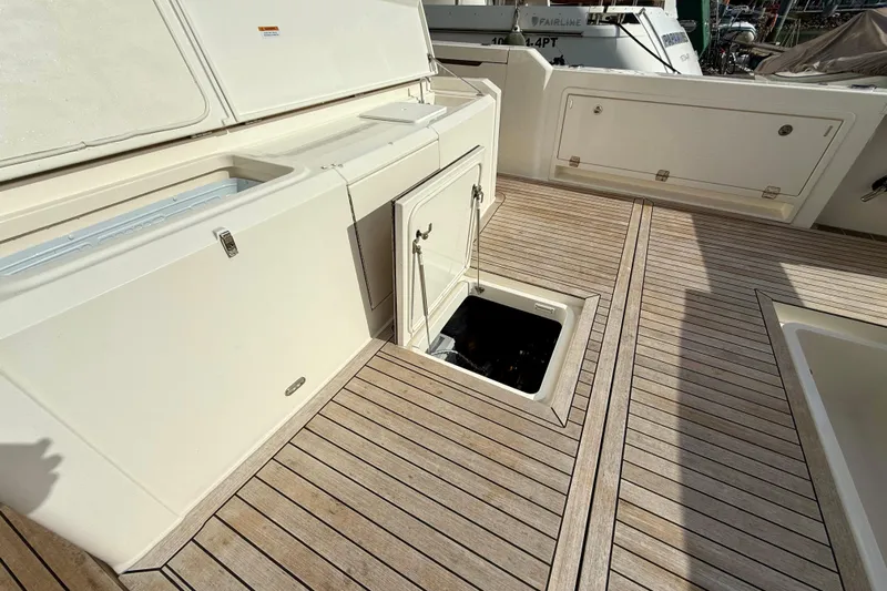  Yacht Photos Pics 2023 Maritimo M600 yacht deck with open storage compartments and teak flooring.