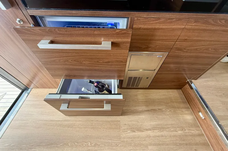  Yacht Photos Pics 2023 Maritimo M600 yacht interior with open wooden drawers and built-in refrigerator.