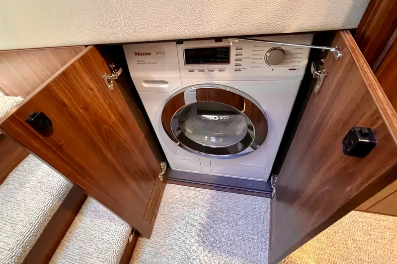  Yacht Photos Pics Built-in Miele washer-dryer in 2023 Maritimo M600 yacht, behind wooden cabinet doors.