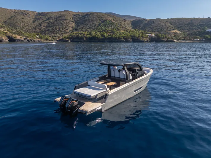 Maxim Yachts | Max43 Race Yacht Photos Pics 2025 Maxim Yachts 43 on serene blue water with scenic hillside backdrop.