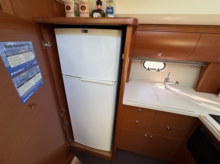  Yacht Photos Pics 2012 Prestige 440 S yacht kitchen with fridge, sink, and wooden cabinetry.