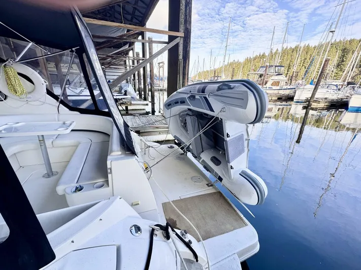  Yacht Photos Pics 2006 Cruisers Yachts 340 Express docked with inflatable boat, serene marina setting.