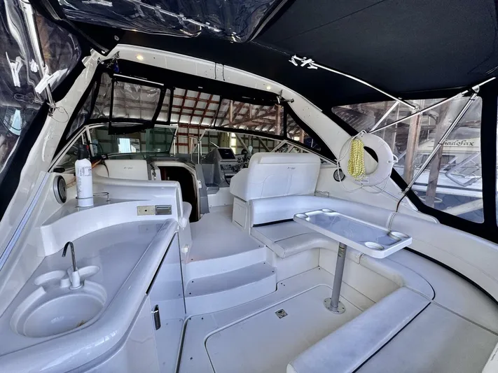  Yacht Photos Pics 2006 Cruisers Yachts 340 Express interior with seating, table, and sink under black canopy.