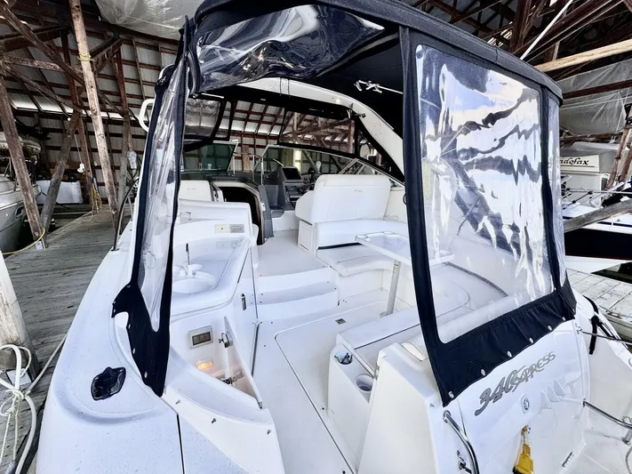  Yacht Photos Pics 2006 Cruisers Yachts 340 Express in a marina, featuring spacious seating and protective canopy.