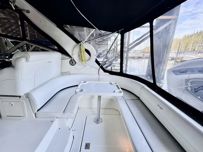  Yacht Photos Pics 2006 Cruisers Yachts 340 Express interior with white seating and table, docked at marina.