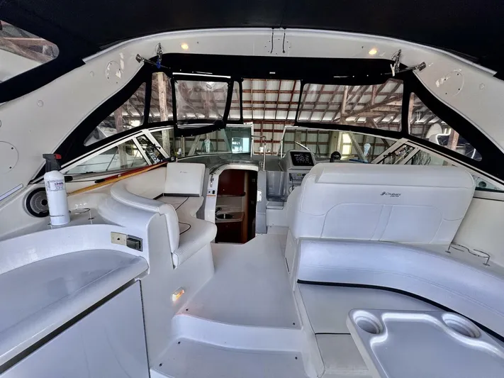  Yacht Photos Pics 2006 Cruisers Yachts 340 Express interior with white seating and helm, under a black canopy.