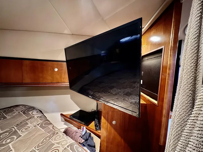  Yacht Photos Pics Interior of 2006 Cruisers Yachts 340 Express with mounted TV and wooden cabinetry.