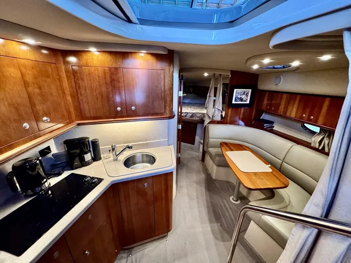  Yacht Photos Pics 2006 Cruisers Yachts 340 Express interior with kitchen, seating area, and wooden cabinetry.