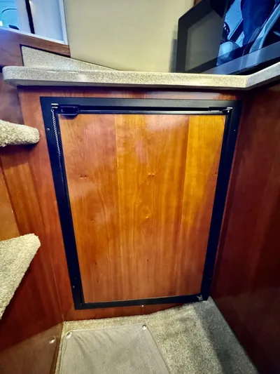  Yacht Photos Pics 2006 Cruisers Yachts 340 Express interior with wooden cabinetry and carpeted steps.