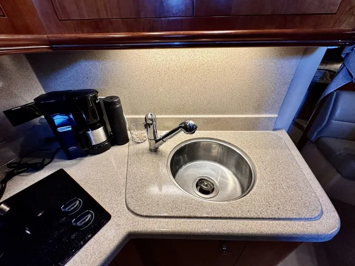  Yacht Photos Pics 2006 Cruisers Yachts 340 Express kitchen with sink, coffee maker, and stovetop.